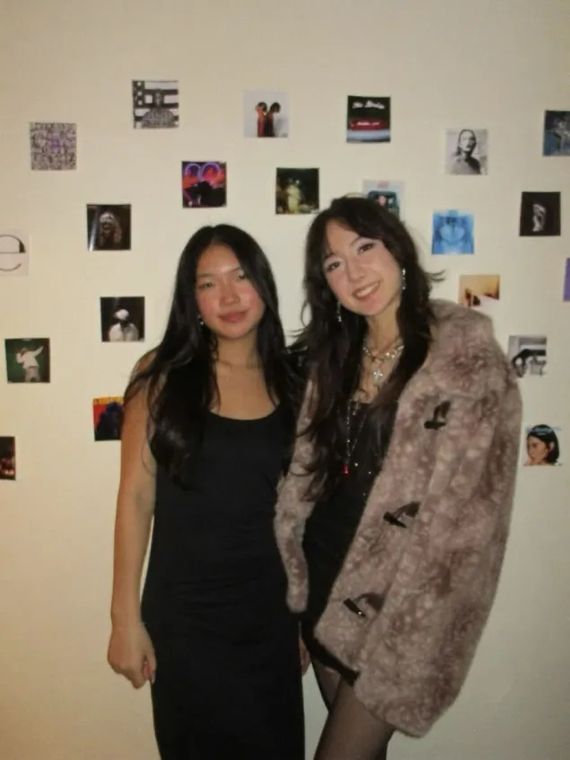Sophi and Mia, co-founders of HoosOnAux, in front of a wall of album covers